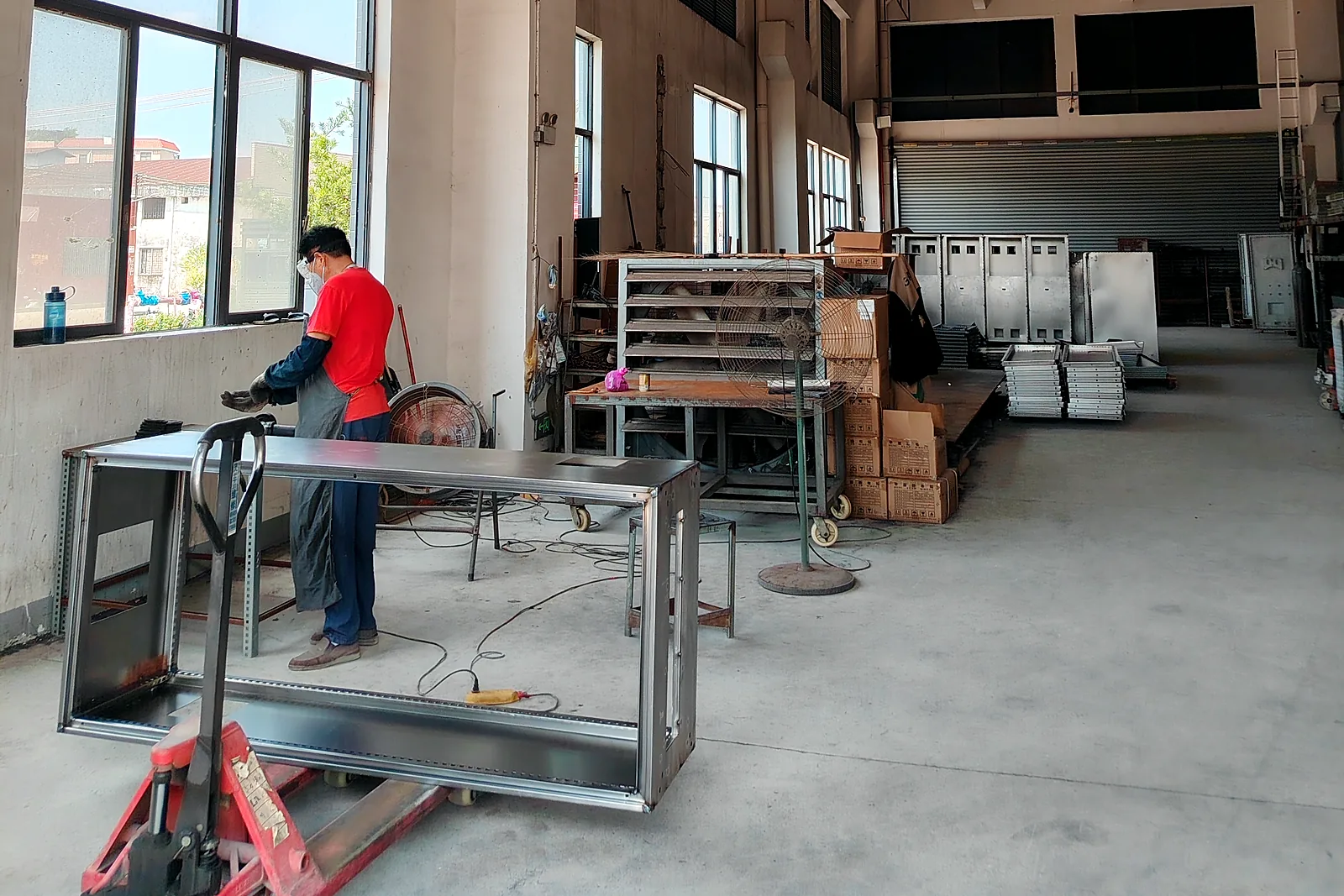 Factory worker fabricating a steel frame for a pet washing machine cabinet